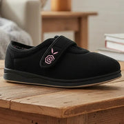 Black women’s slippers with pink floral embroidery on strap and low rubber sole