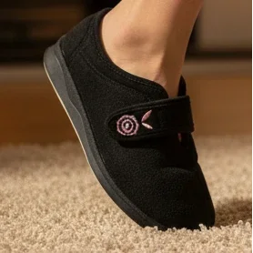 Black women’s slip-on slippers with pink floral emblem on front strap