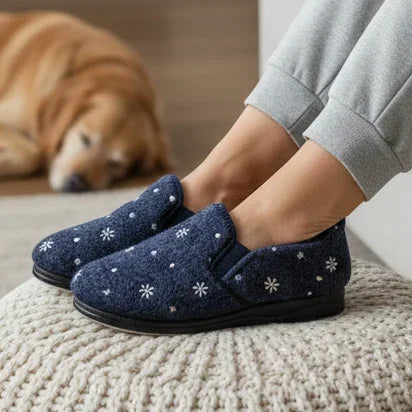 Women’s navy slip-on slippers with white floral pattern and black sole, close-up