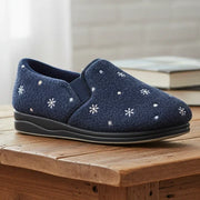 Women’s navy slip-on slippers on wooden surface, white flower print, black sole