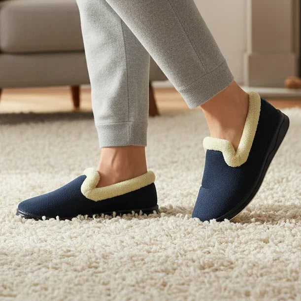 Navy plush slip-on slippers with light tan paw appliqué and dark heel trim