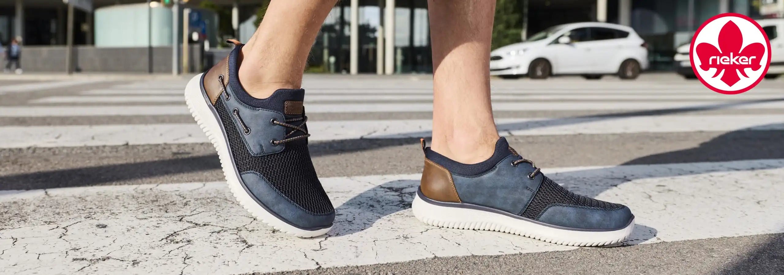 Person wearing navy blue sneakers on a city street with Rekker brand logo.