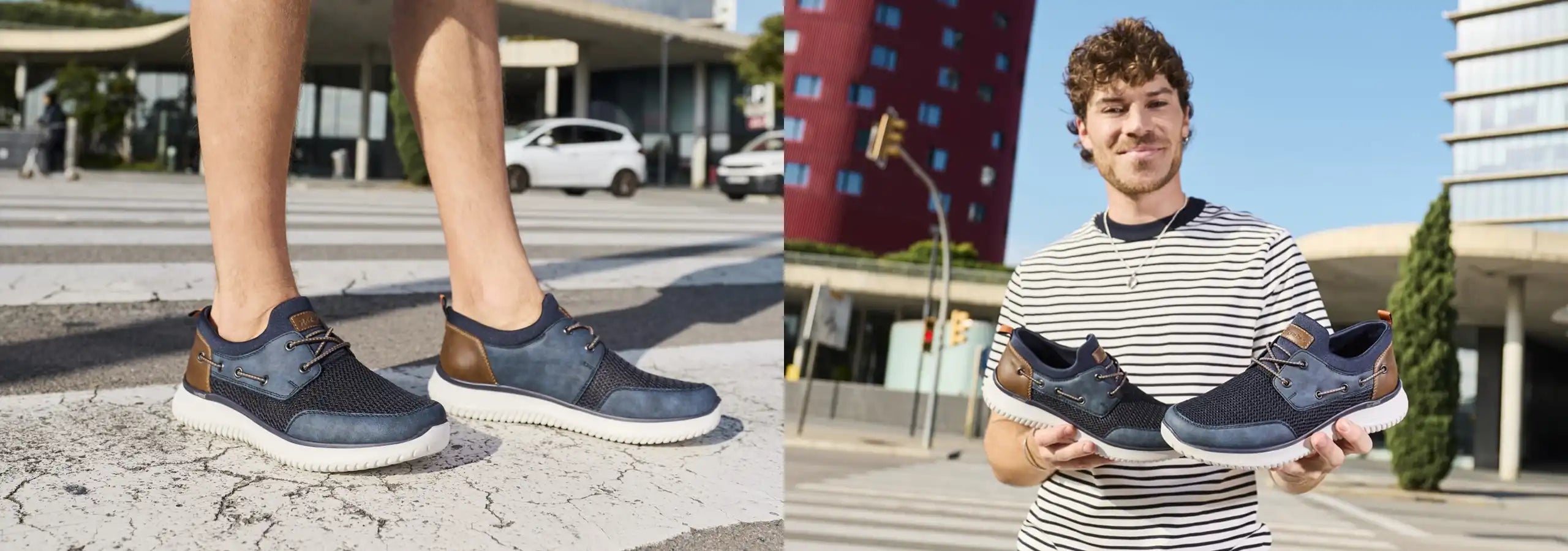 Person wearing navy sneakers on a street and holding up two pairs of navy sneakers.